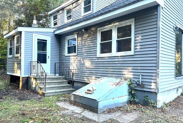 a view of a house with a door and wooden fence