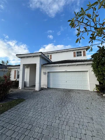 a view of a house with a yard and potted plants