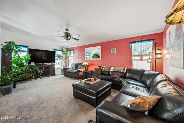 a living room with furniture a flat screen tv and a window