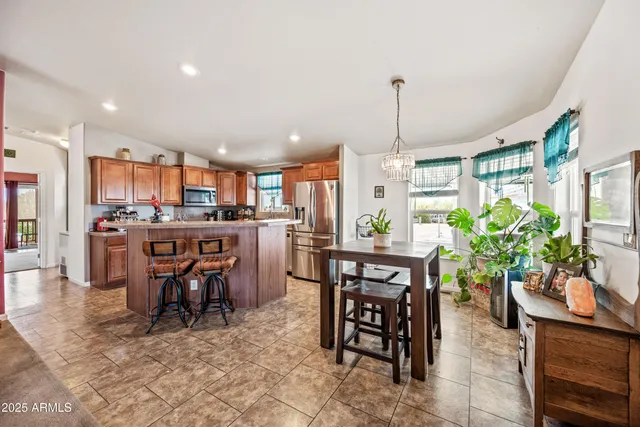 a dining room filled chandelier and kitchen view