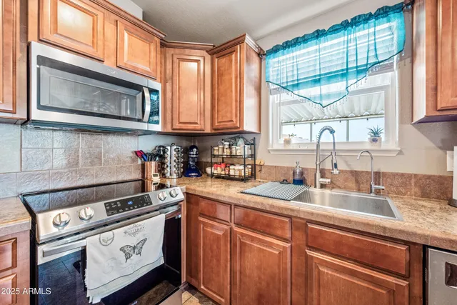a kitchen with stainless steel appliances granite countertop a sink a stove and cabinets