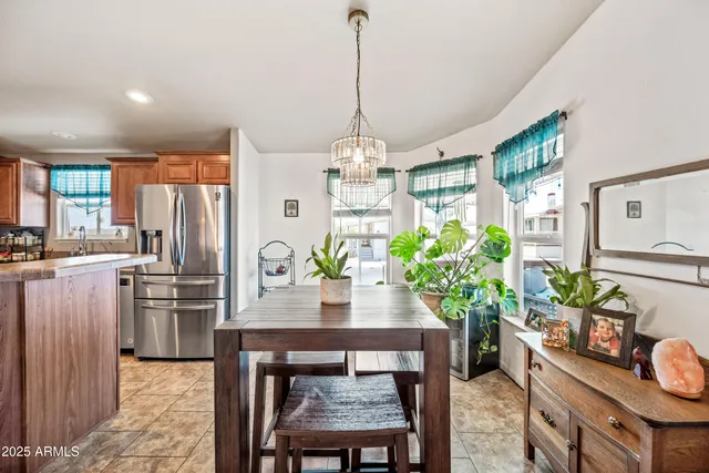 a dining room filled chandelier and kitchen view