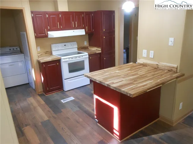 a kitchen with granite countertop wood cabinets and white appliances