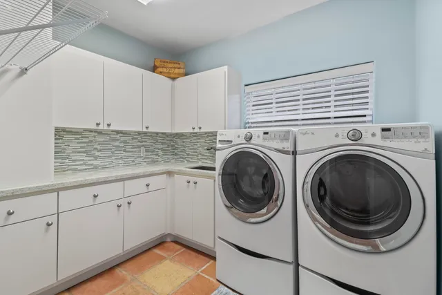 a kitchen that has a lot of cabinets a sink and a stove in it