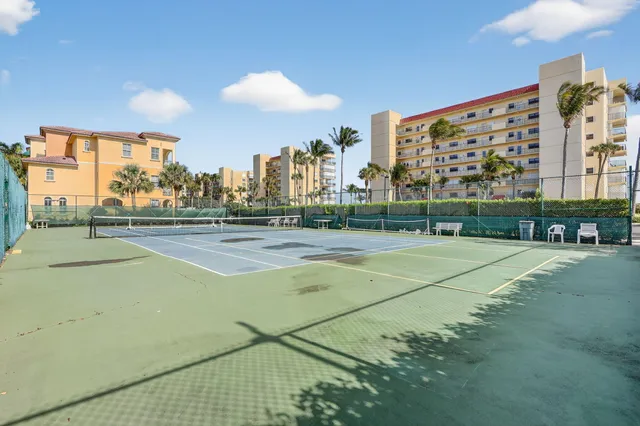 a front view of a building with cars parked