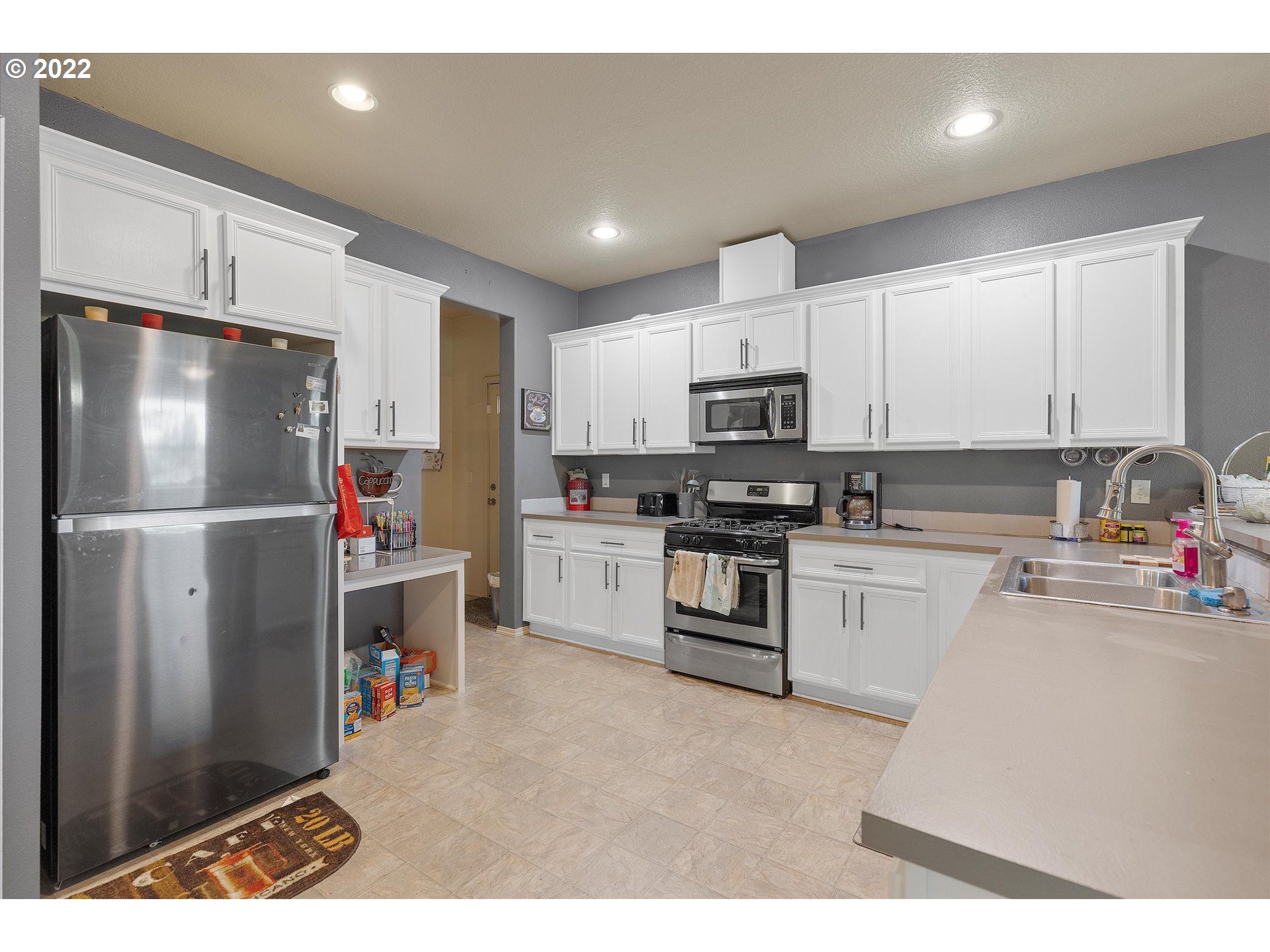 40310 Dubarko Road Sandy, OR 97055 - Photo 5 of 23 a kitchen with white cabinets and stainless steel appliances