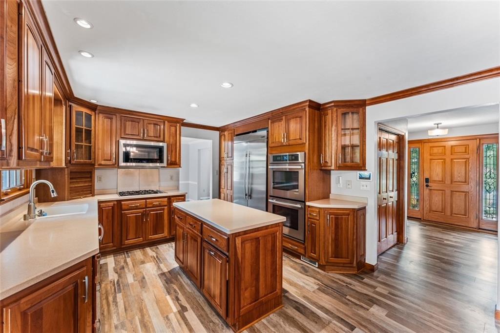120 Timothy Road Gibsonia, PA 15044 - Photo 12 of 50 a kitchen with stainless steel appliances a stove top oven a sink dishwasher and wooden cabinets with wooden floor