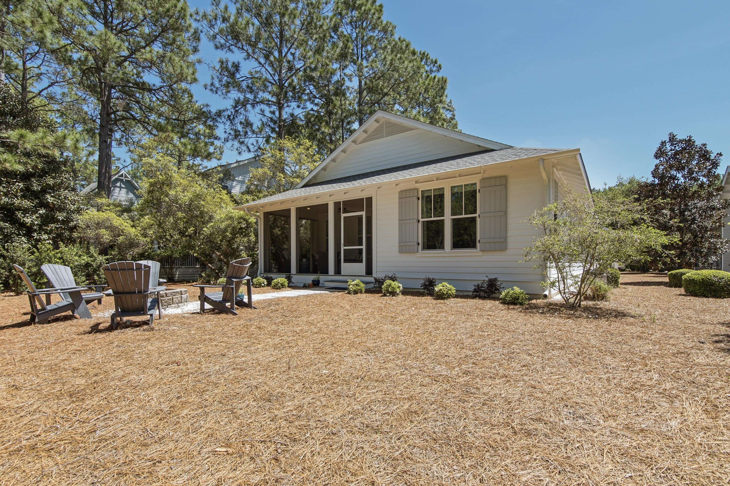 755 Breakers Street, Unit LOT 50 Inlet Beach, FL 32461 - Photo 46 of 61 a backyard of a house with table and chairs under an umbrella