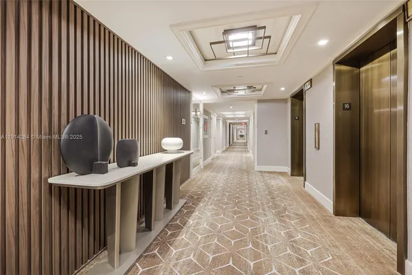 a view of a hallway with entryway wooden floor and windows