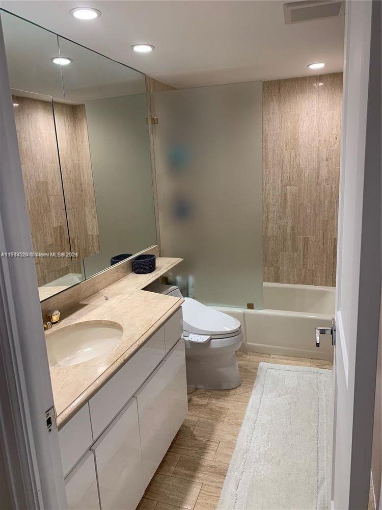 2 Grove Isle Drive, Unit B1507 Miami, FL 33133 - Photo 7 of 13 a bathroom with a granite countertop sink a toilet and shower