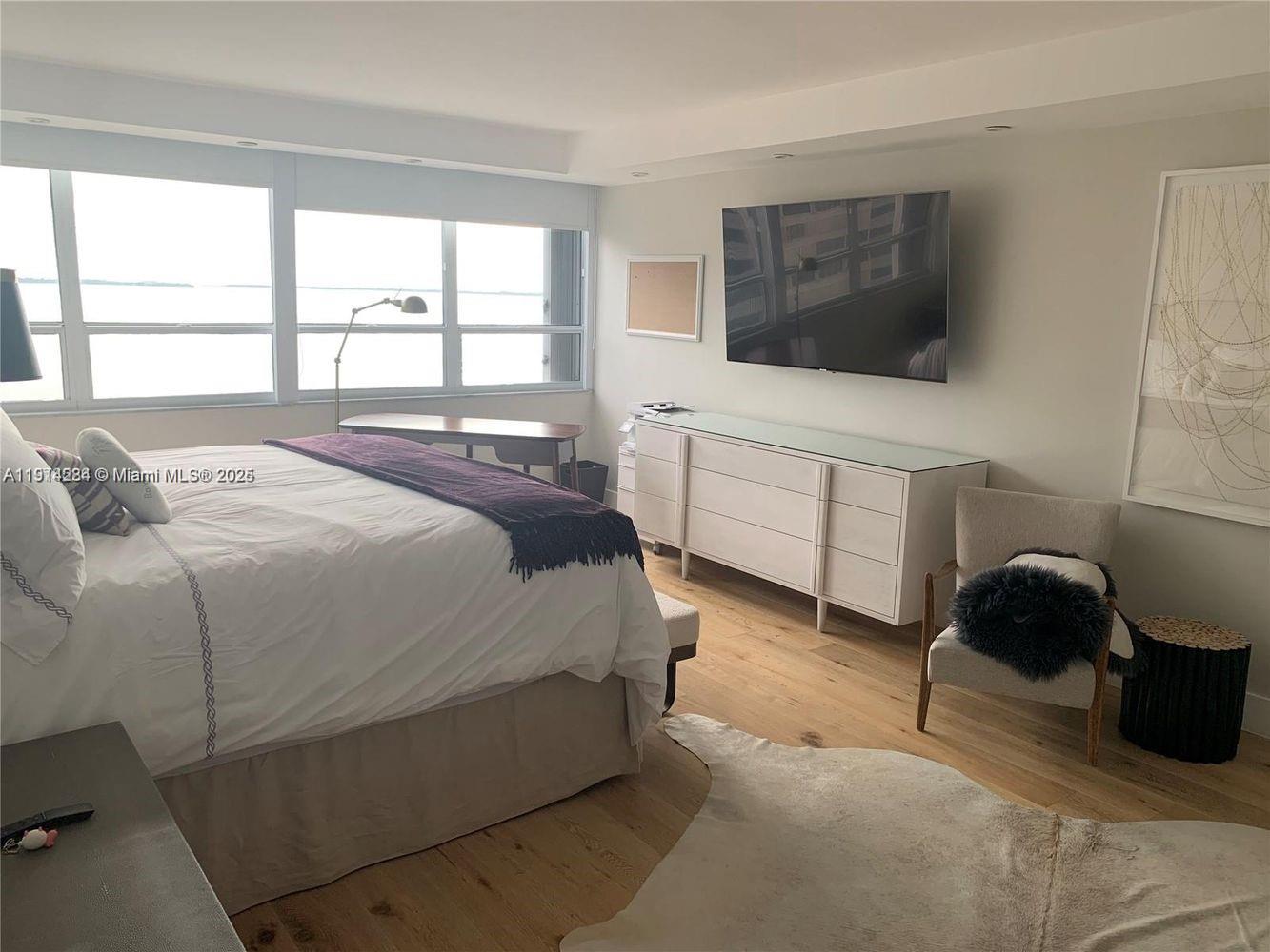 2 Grove Isle Drive, Unit B1507 Miami, FL 33133 - Photo 10 of 13 a bedroom with a bed and a flat screen tv