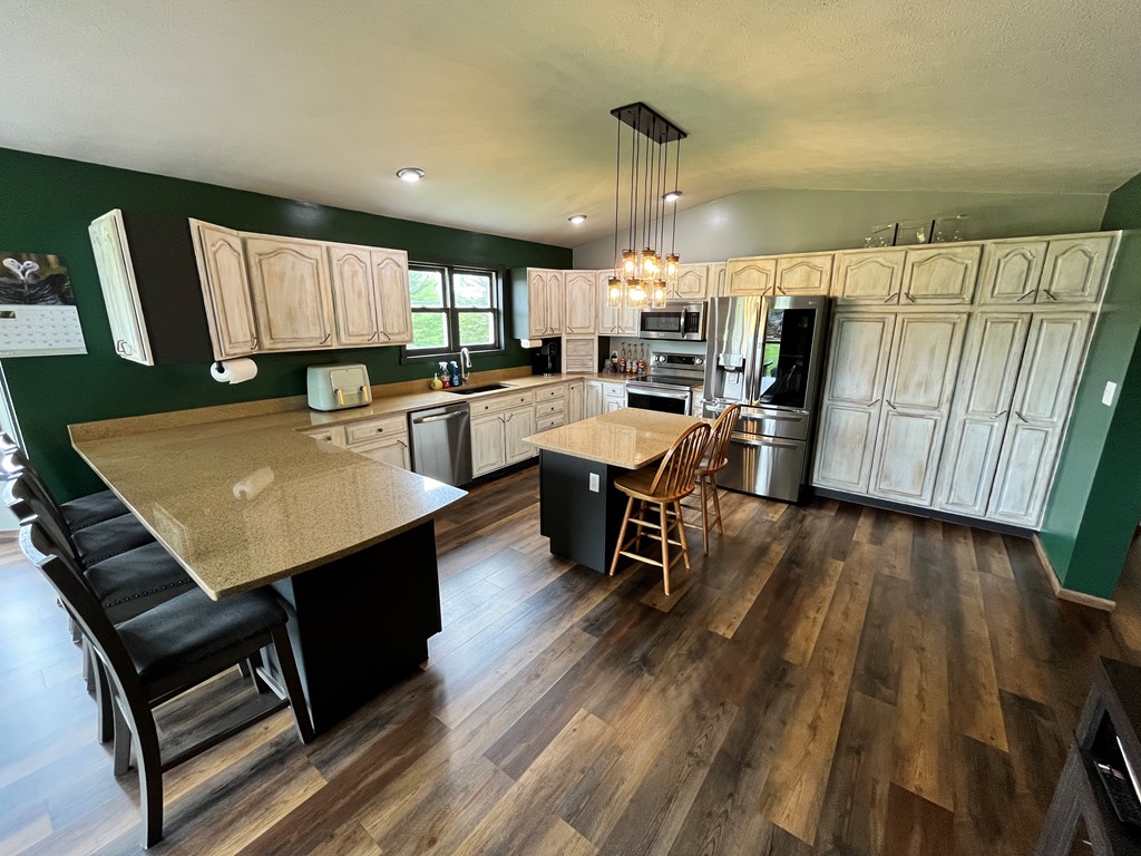 2761 Bush Road Spring Creek, PA 16436 - Photo 25 of 86 a kitchen with stainless steel appliances kitchen island granite countertop a table chairs and a refrigerator