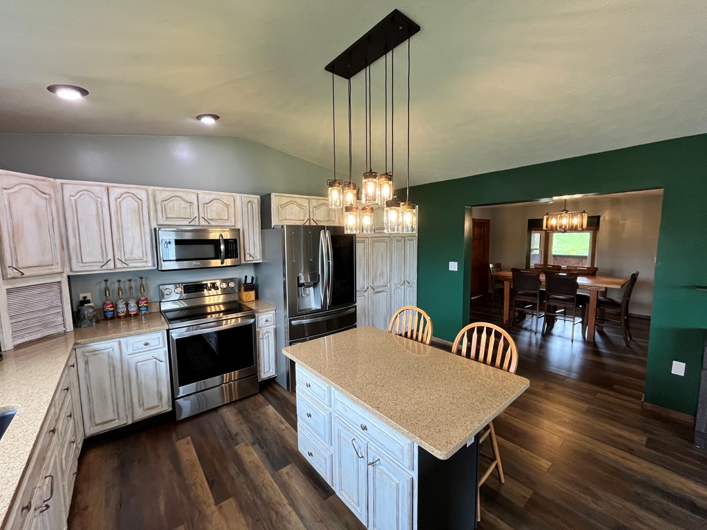 2761 Bush Road Spring Creek, PA 16436 - Photo 28 of 86 a kitchen with stainless steel appliances granite countertop a kitchen island hardwood floor sink stove dining table and chairs