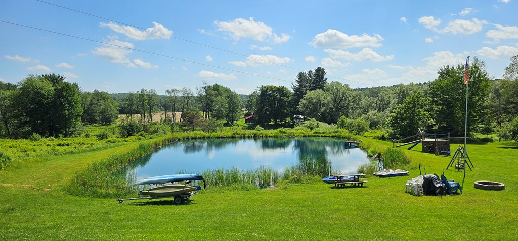 2761 Bush Road Spring Creek, PA 16436 - Photo 6 of 86 a view of a lake with a yard and a fountain