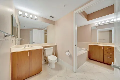a view of empty room with wooden floor and kitchen