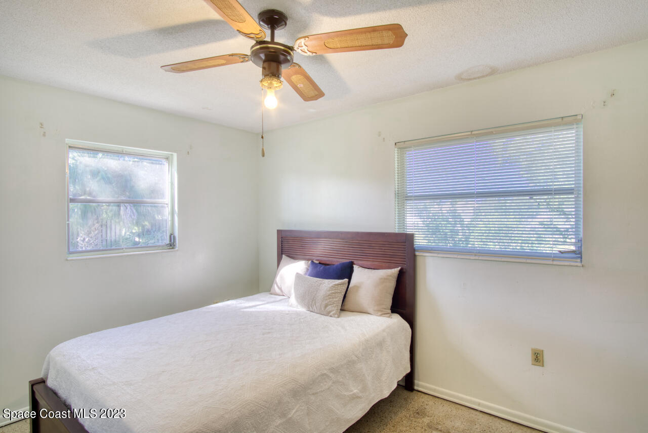 3101 Dairy Road Melbourne, FL 32901 - Photo 12 of 28 a bedroom with a bed and a chandelier
