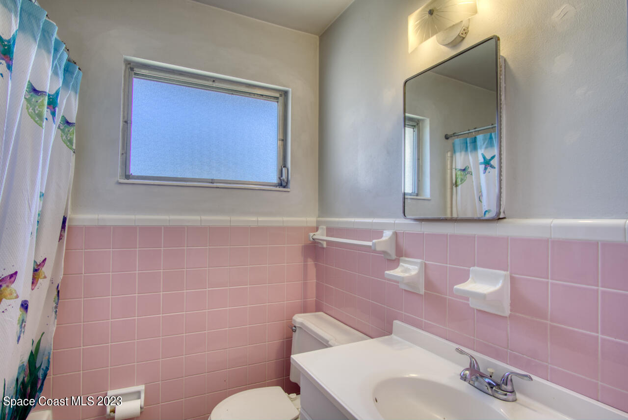 3101 Dairy Road Melbourne, FL 32901 - Photo 13 of 28 a bathroom with a toilet sink and mirror
