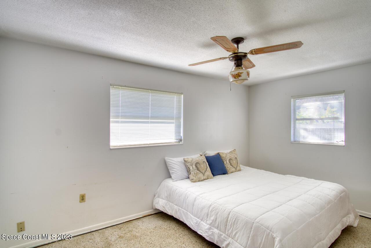3101 Dairy Road Melbourne, FL 32901 - Photo 14 of 28 a bedroom with a bed and a ceiling fan