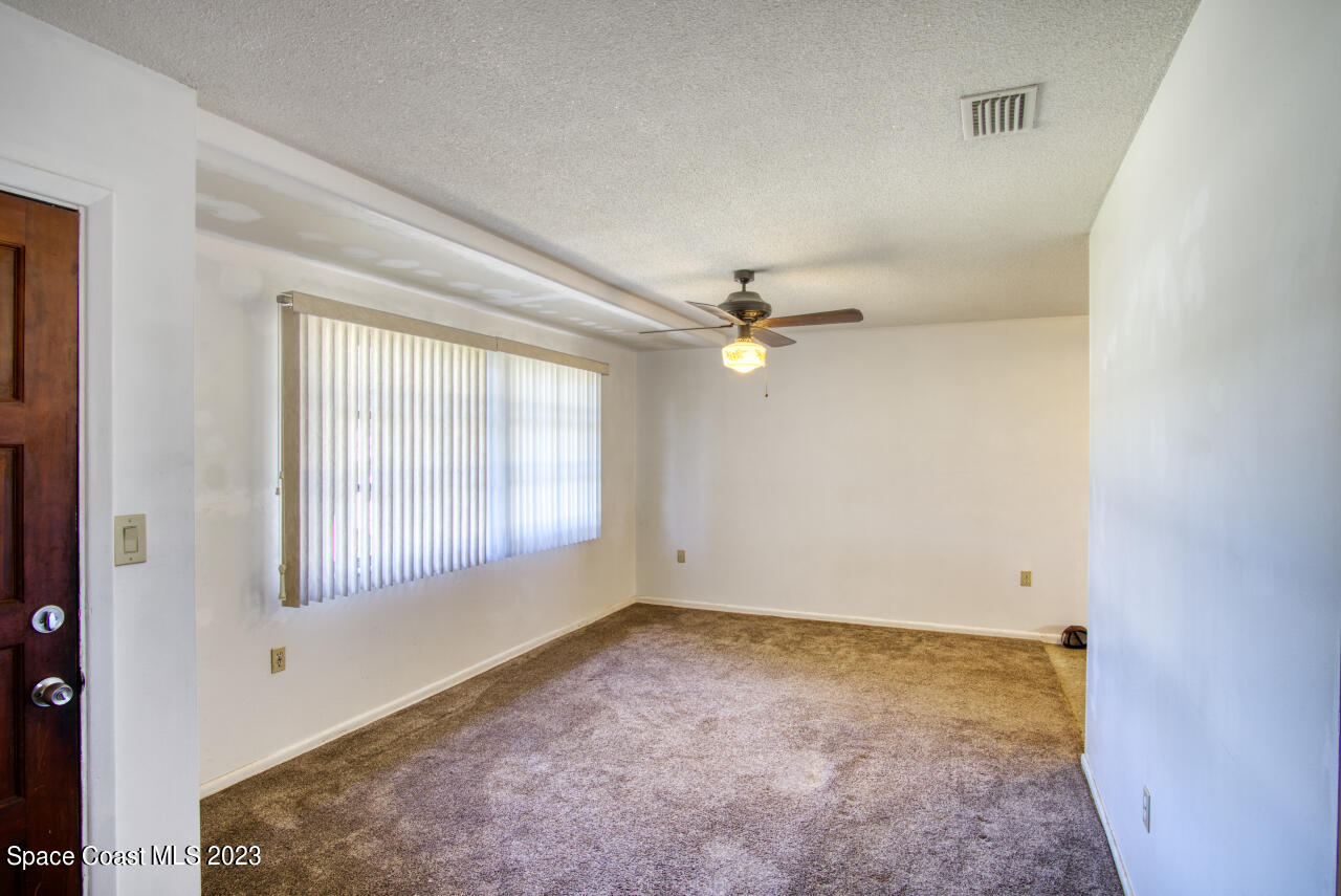 3101 Dairy Road Melbourne, FL 32901 - Photo 3 of 28 an empty room with windows and ceiling fan