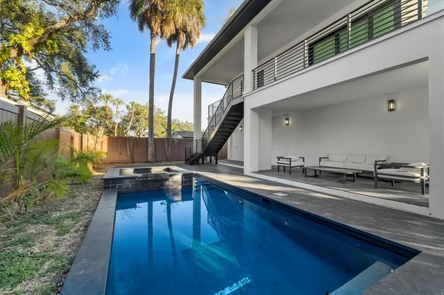 a kitchen with stainless steel appliances granite countertop a stove a sink a window and chairs