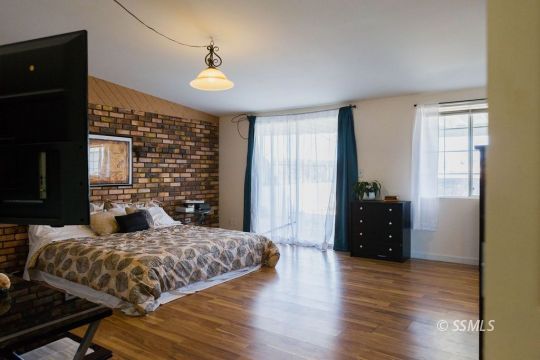 308 West Howell Avenue Ridgecrest, CA 93555 - Photo 16 of 32 a bedroom with a bed and wooden floor