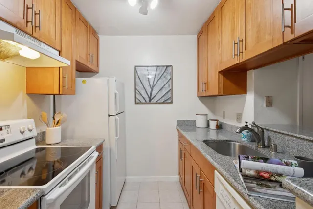 a kitchen with stainless steel appliances granite countertop a sink stove and cabinets