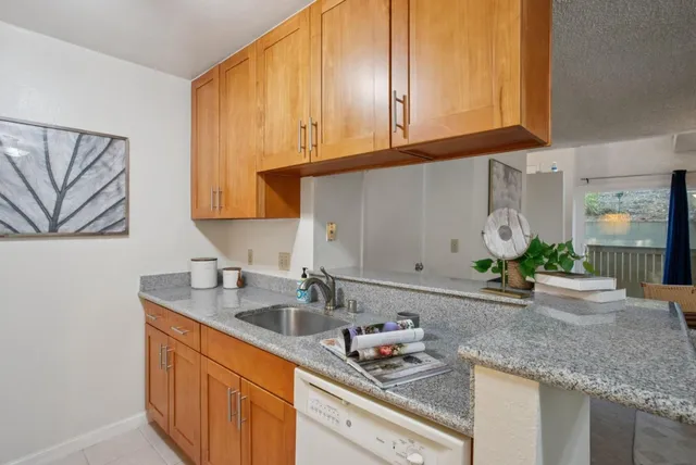 a kitchen with stainless steel appliances granite countertop a sink a stove and cabinets