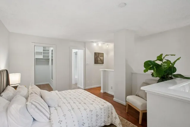 a bedroom with a bed and a potted plant