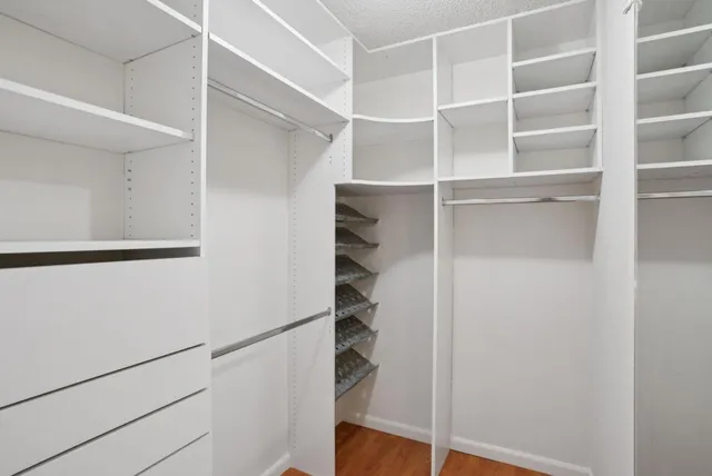a view of walk in closet with empty racks