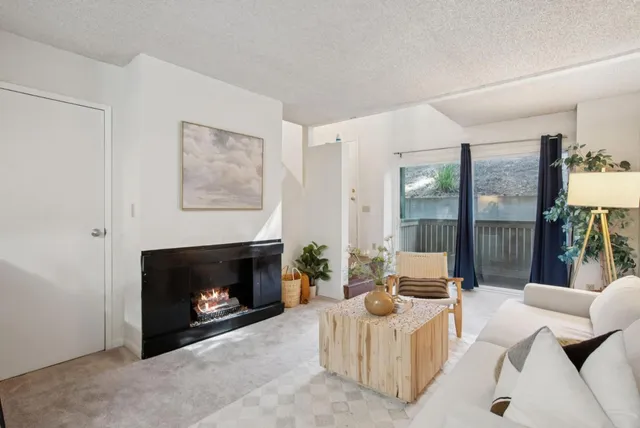 a living room with furniture a large window and a fireplace