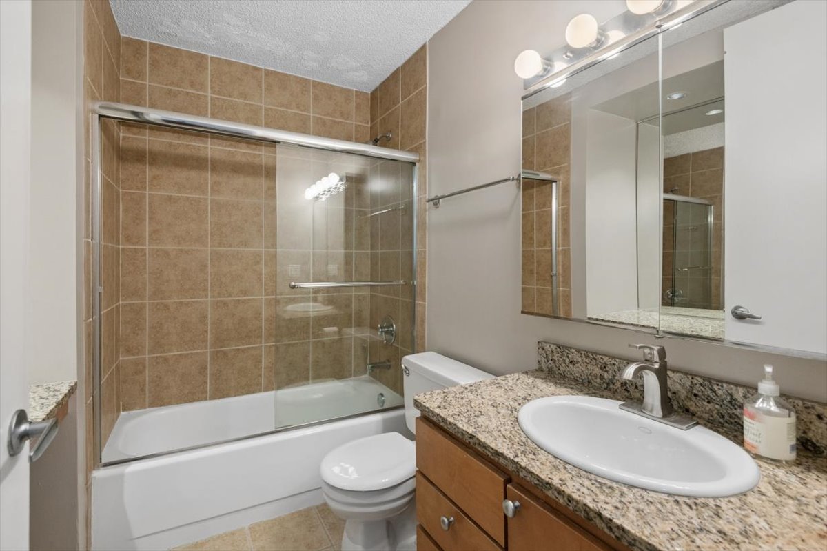 30 East Huron Street, Unit 2204 Chicago, IL 60611 - Photo 13 of 36 a bathroom with a granite countertop sink toilet mirror and shower