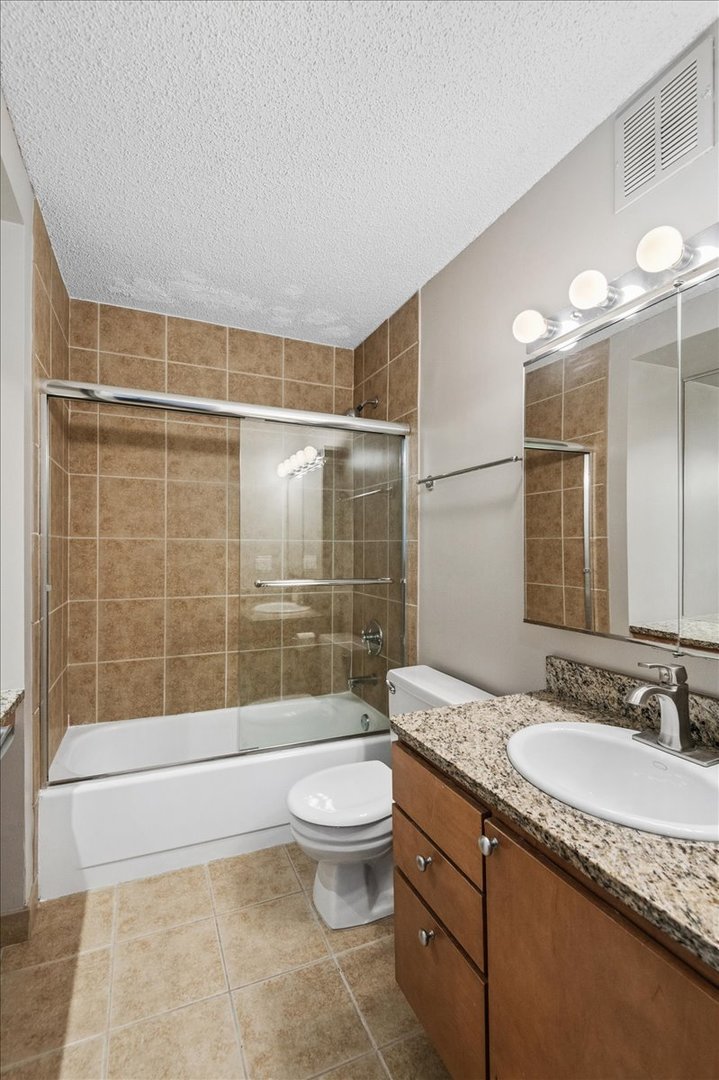 30 East Huron Street, Unit 2204 Chicago, IL 60611 - Photo 14 of 36 a bathroom with a granite countertop sink a toilet a mirror and shower