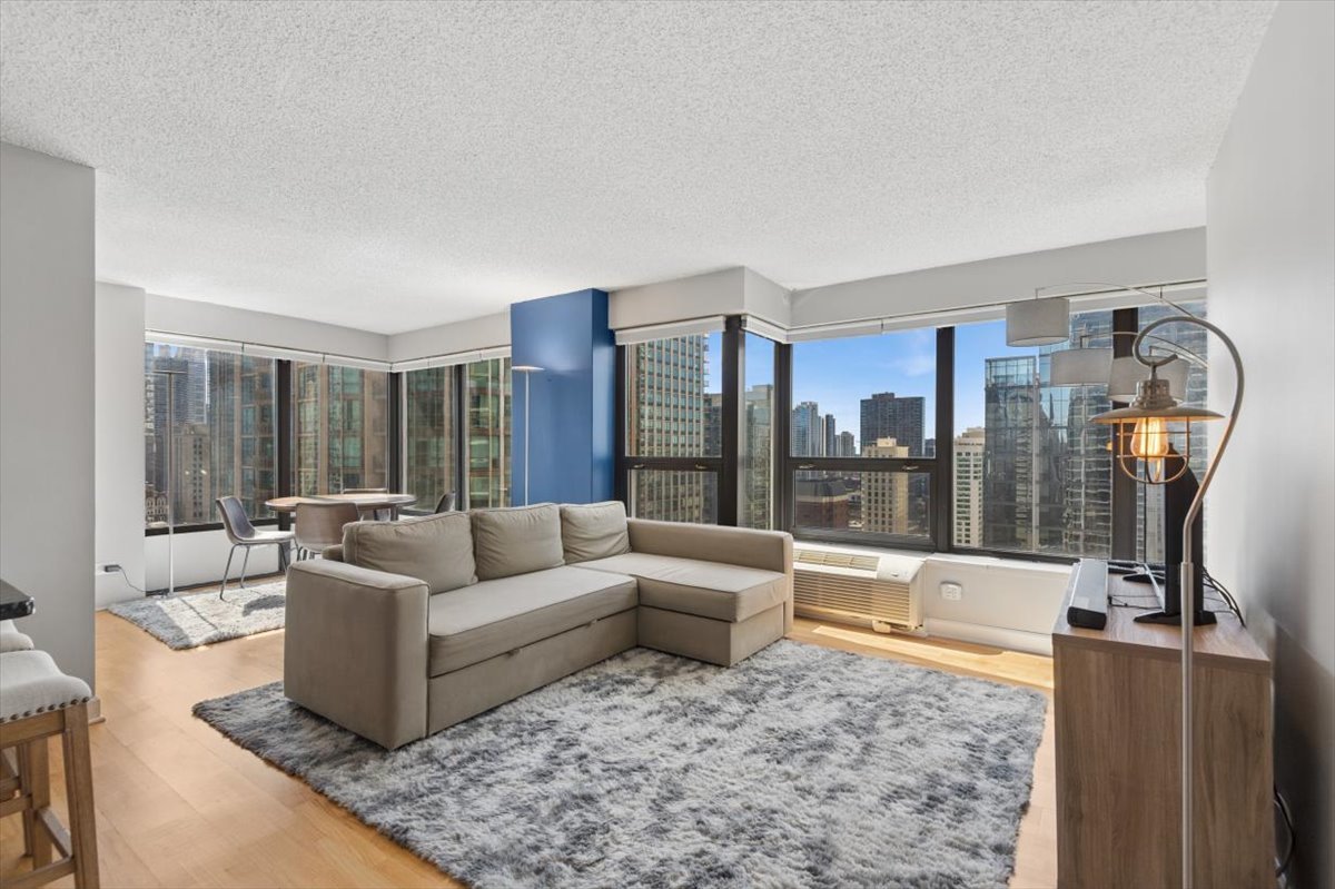 30 East Huron Street, Unit 2204 Chicago, IL 60611 - Photo 3 of 36 a living room with furniture and a floor to ceiling window