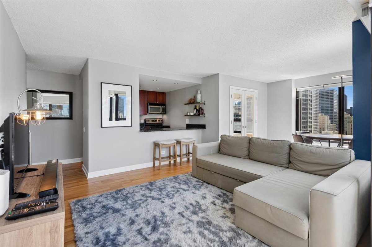30 East Huron Street, Unit 2204 Chicago, IL 60611 - Photo 4 of 36 a living room with furniture and a wooden floor