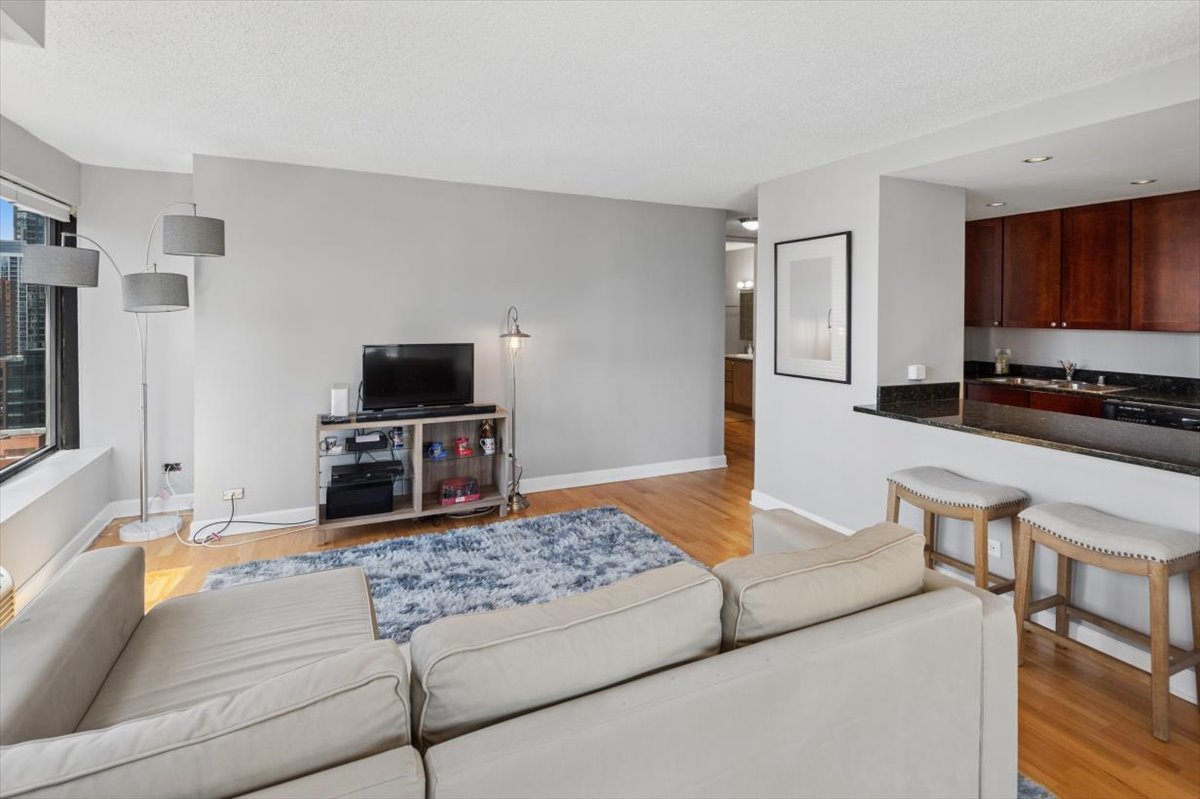 30 East Huron Street, Unit 2204 Chicago, IL 60611 - Photo 5 of 36 a living room with furniture and a flat screen tv