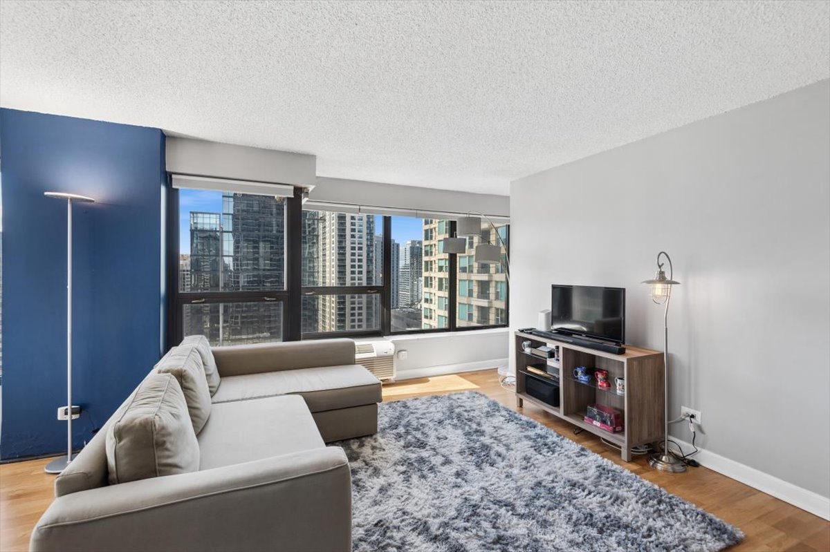 30 East Huron Street, Unit 2204 Chicago, IL 60611 - Photo 6 of 36 a living room with furniture a flat screen tv and a rug
