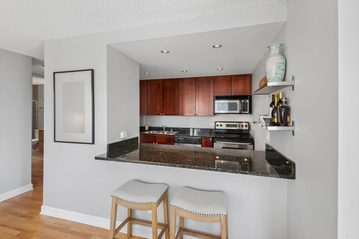 30 East Huron Street, Unit 2204 Chicago, IL 60611 - Photo 8 of 36 a kitchen with stainless steel appliances granite countertop a refrigerator a stove top oven a sink and dishwasher