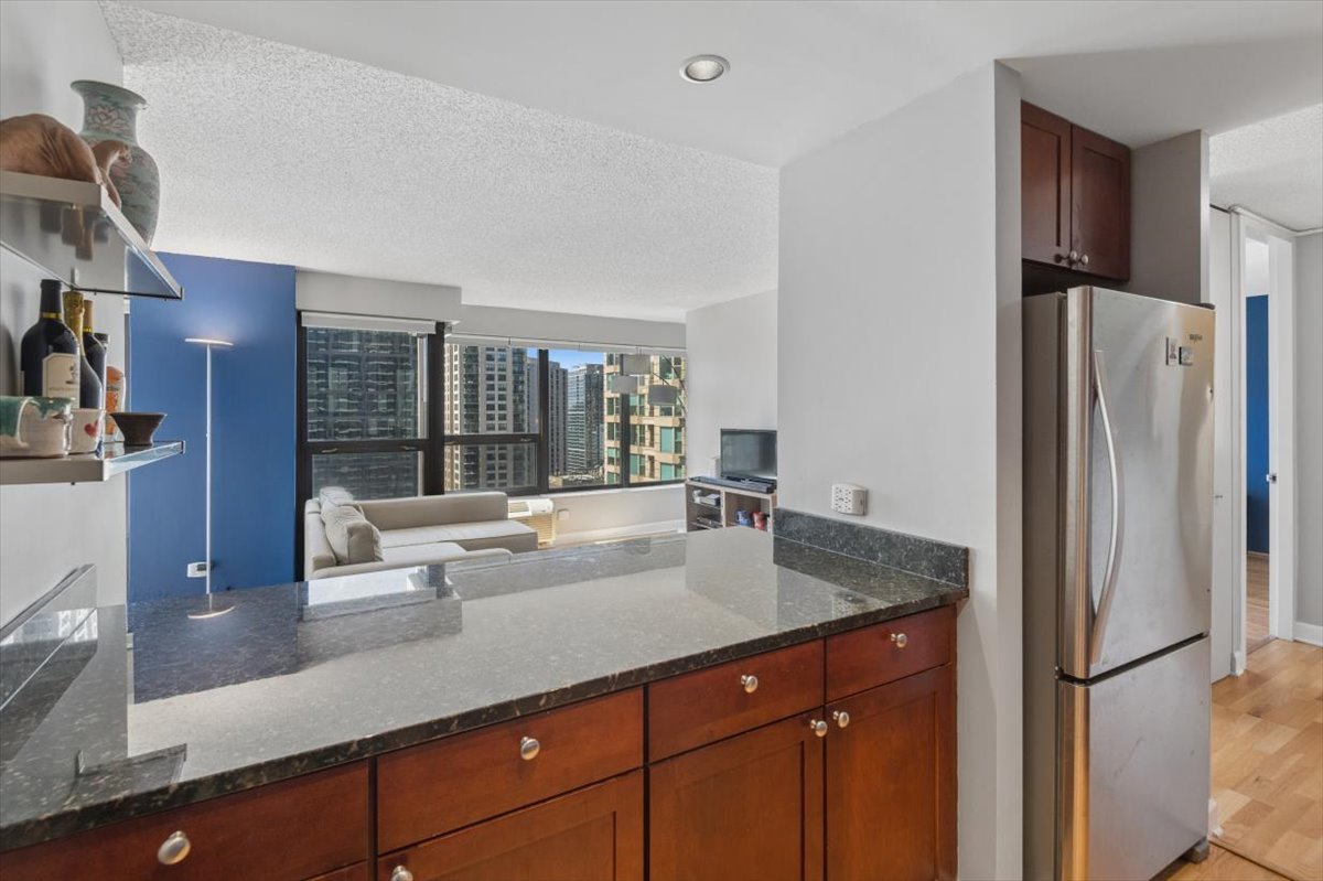 30 East Huron Street, Unit 2204 Chicago, IL 60611 - Photo 10 of 36 a kitchen with stainless steel appliances granite countertop a refrigerator and a sink