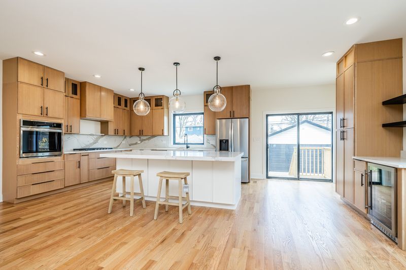 2247 South 6th Avenue North Riverside, IL 60546 - Photo 13 of 57 a large kitchen with granite countertop a stove a sink a dining table and chairs with wooden floor