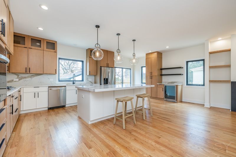 2247 South 6th Avenue North Riverside, IL 60546 - Photo 19 of 57 a kitchen with stainless steel appliances kitchen island wooden floors stove and white cabinets