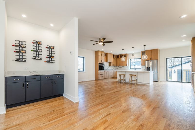 2247 South 6th Avenue North Riverside, IL 60546 - Photo 9 of 57 a living room with stainless steel appliances kitchen island granite countertop a refrigerator a stove a dining table and chairs with wooden floor