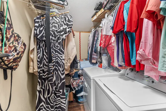 a view of walk in closet with clothes and shoes