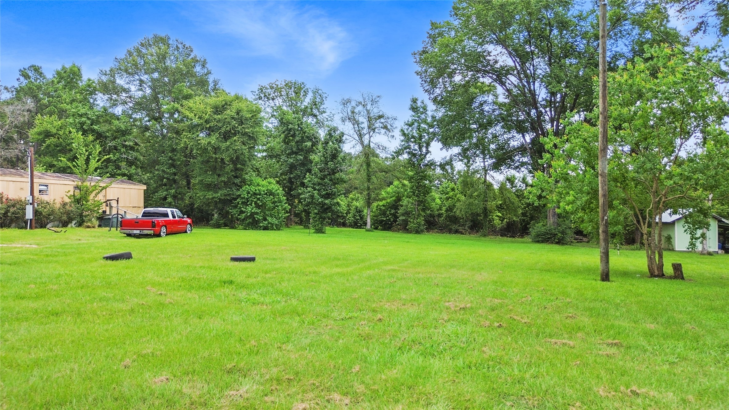 228 Geneva Road Huntsville, TX 77320 - Photo 21 of 26 a green field with lots of trees in the background