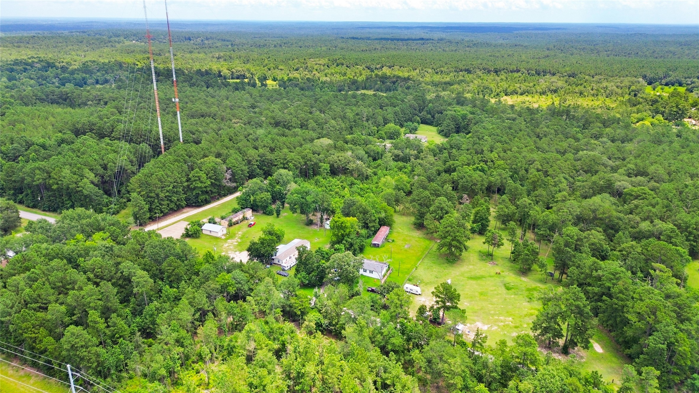 228 Geneva Road Huntsville, TX 77320 - Photo 23 of 26 a view of a lush green forest with trees and some houses
