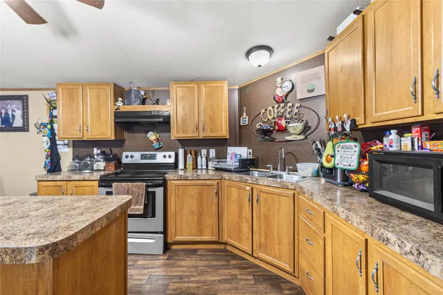 a kitchen with stainless steel appliances granite countertop a sink stove and cabinets