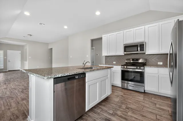 a kitchen with granite countertop a stove and a sink