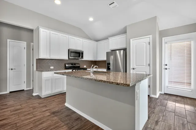 a kitchen with stainless steel appliances granite countertop a refrigerator stove microwave and sink