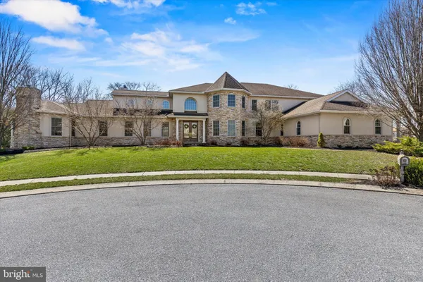 a view of a big house in a big yard with large trees