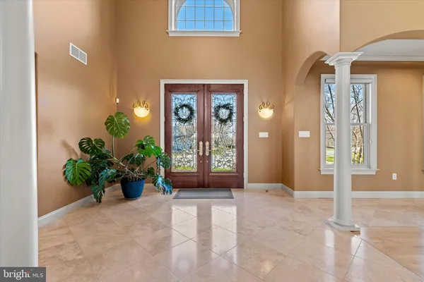 an empty room with wooden floor chandelier and entryway