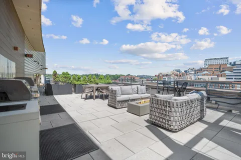 a view of a roof deck with couches and potted plants